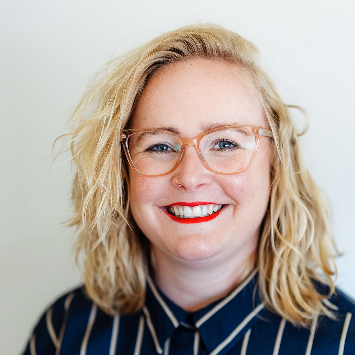 Portret van Jolien, EFT-relatiecounselor bij Voordeliefde, met bril en gestreepte blouse