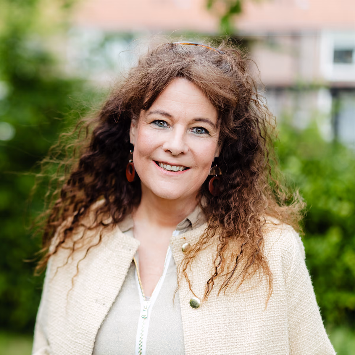Portret van Carolien, EFT-relatiecounselor bij Voordeliefde, glimlachend in een groene buitenomgeving