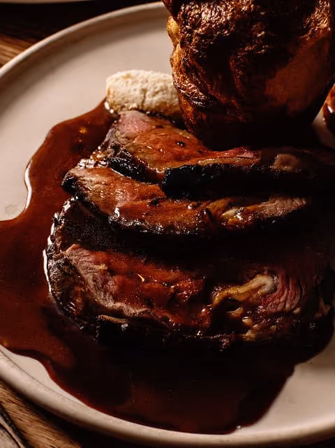 A freshly baked Yorkshire pudding served alongside roast sides.
