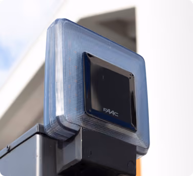Close-up of a blue FAAC security gate or barrier sensor device mounted outdoors.