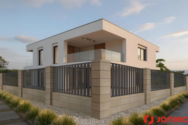 Modern two-story house with white walls and glass balcony behind a beige stone and gray metal fence.