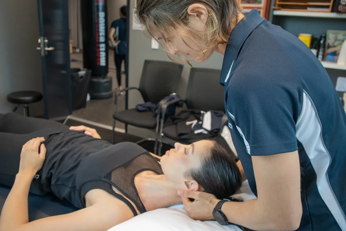 Physiotherapist mobilising a patient's neck during a whiplash assessment