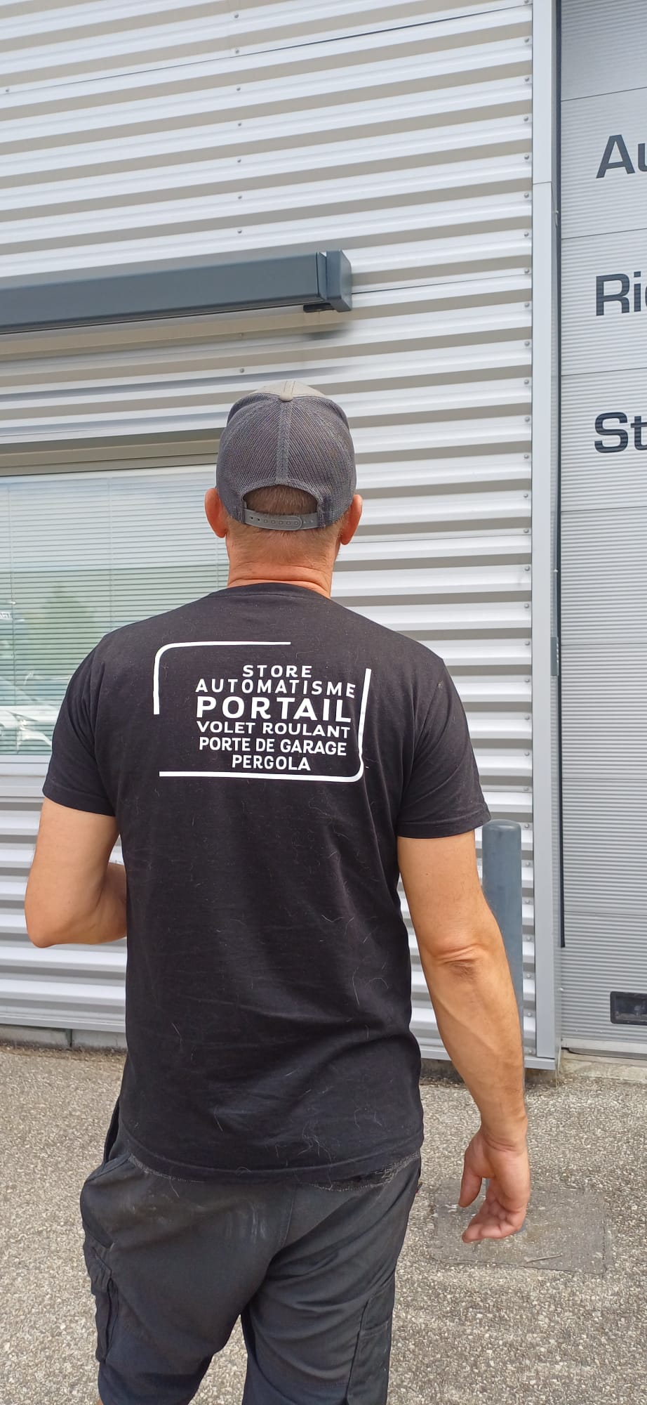 Homme de dos avec casquette et t-shirt noir listant des services d'automatisme et portail.