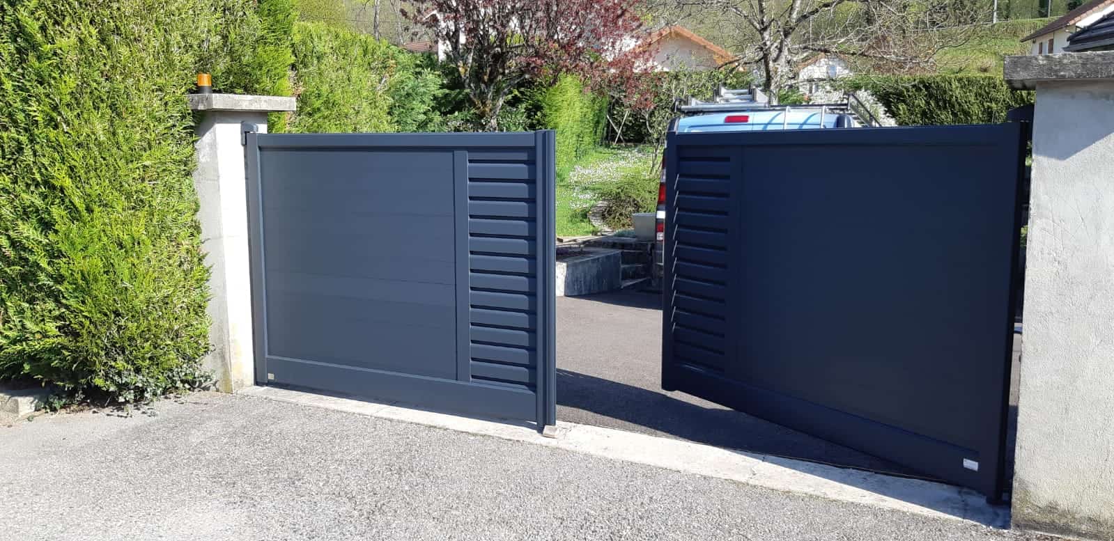 Portail battant en aluminium à deux vantaux entre deux piliers