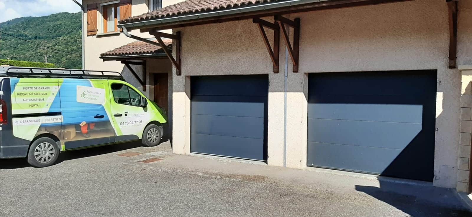Véhicule DVD Industries devant une maison équipée de deux portes de garage sectionnelles
