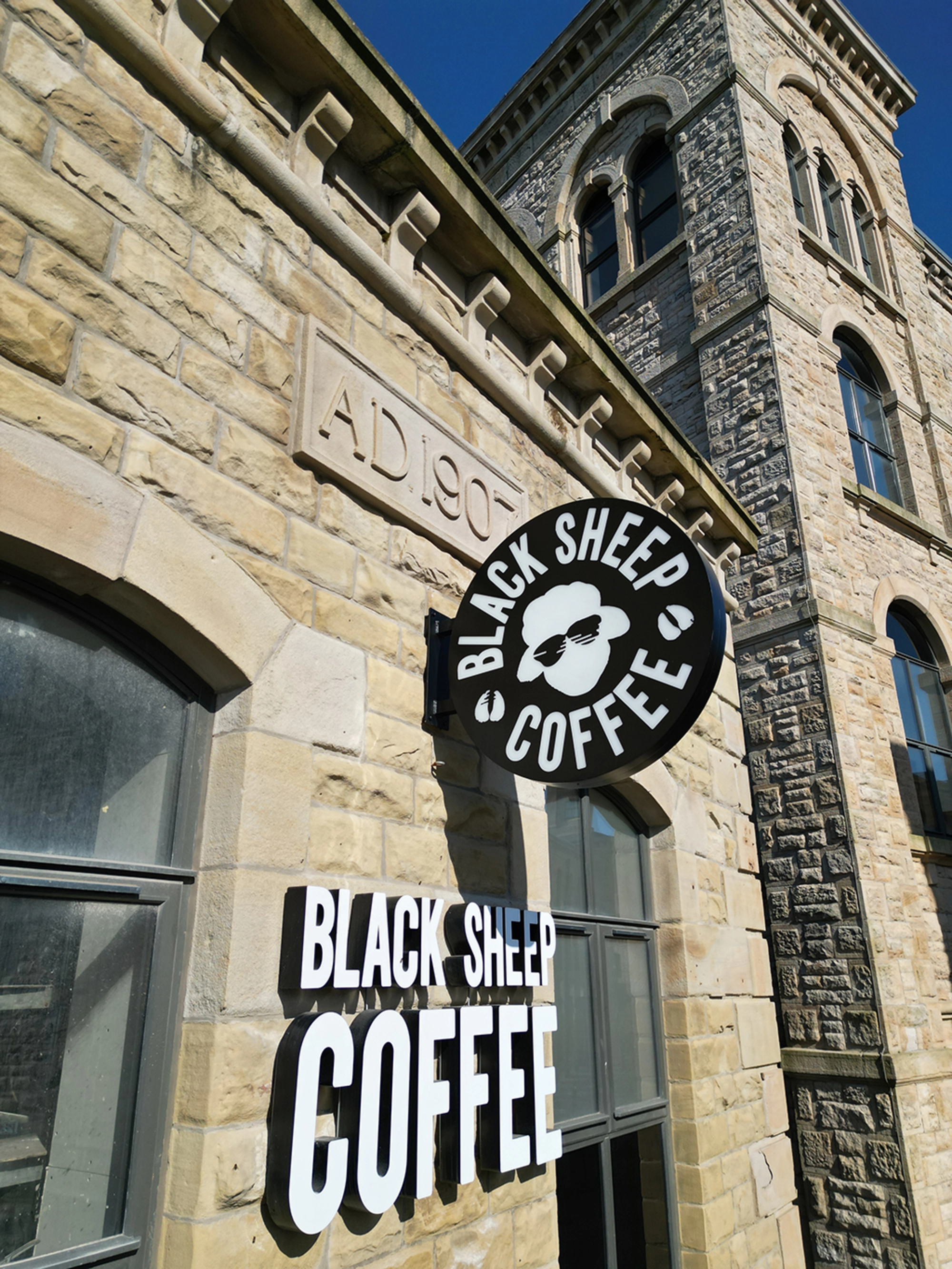 Exterior photograph of the Black Sheep Coffee signage against the Northlight mill stonework