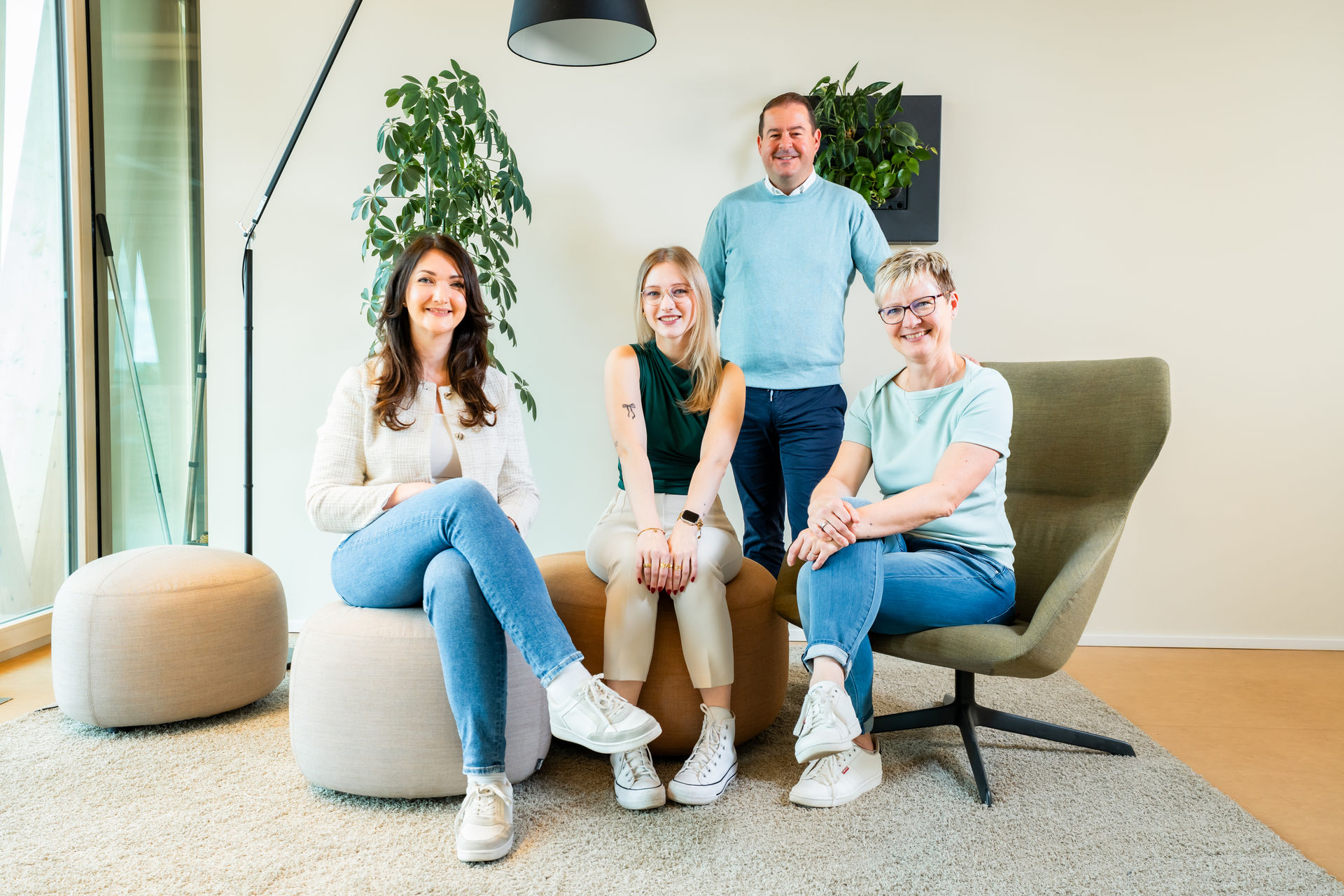 Team der b+ GmbH sitzt zusammen in der Büro-Lounge.