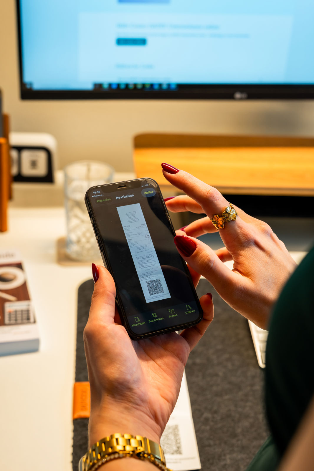 Buchhalterin arbeitet konzentriert am Smartphone in moderner Büroumgebung.