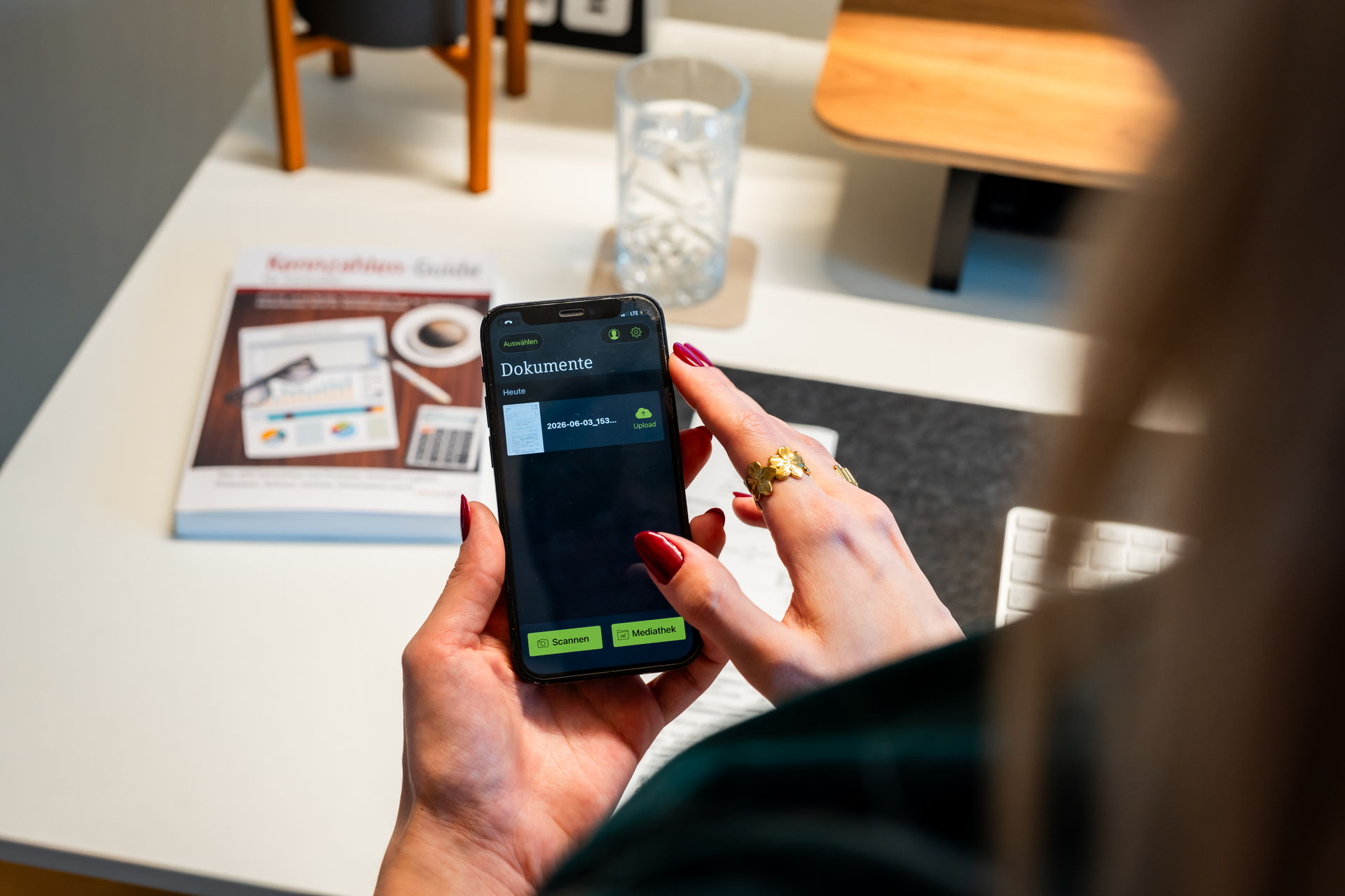 Hand scannt ein Dokument mit einer Smartphone-App für digitale Belegerfassung.