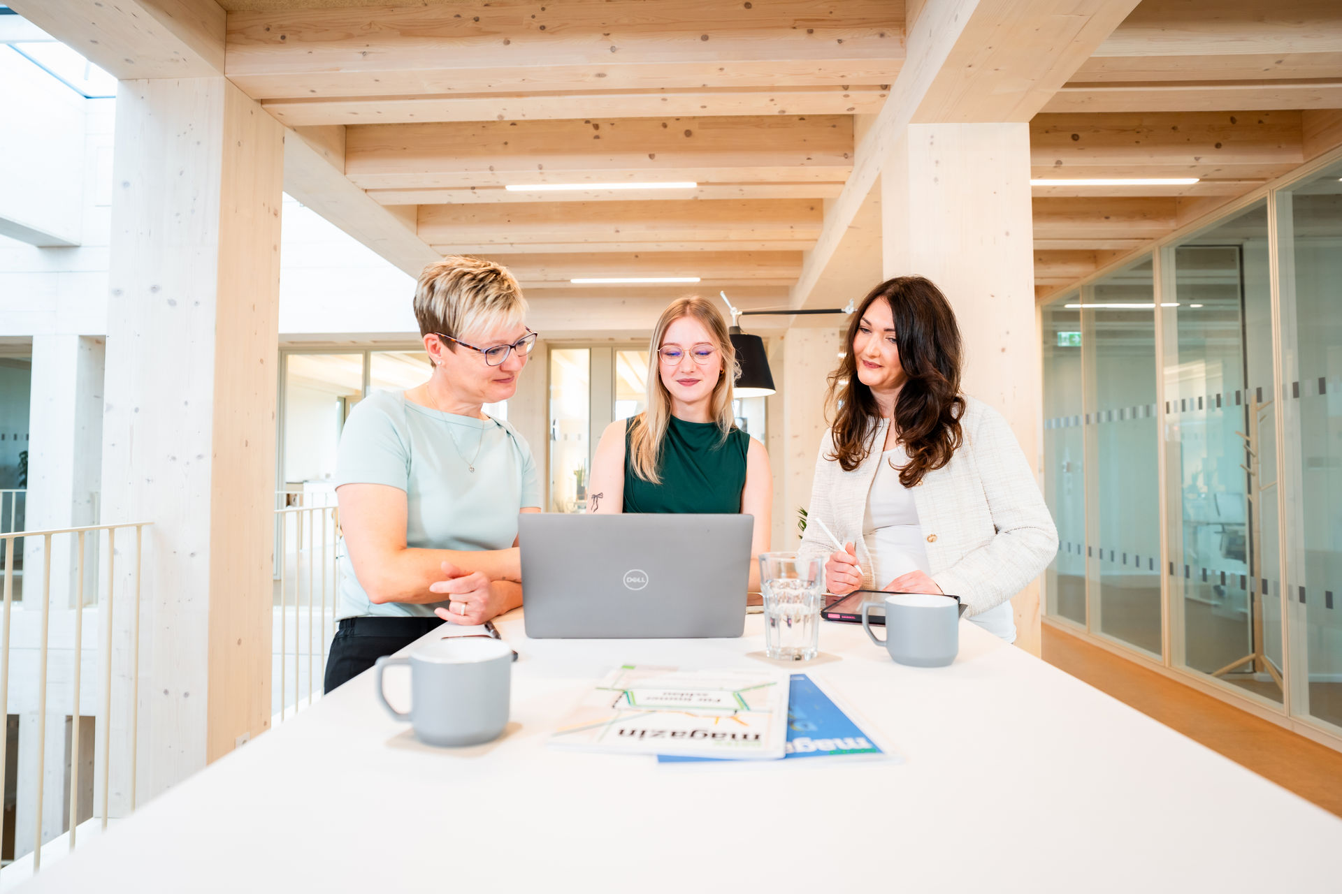 Drei Mitglieder des b+ GmbH Teams besprechen gemeinsam Buchhaltungsunterlagen.