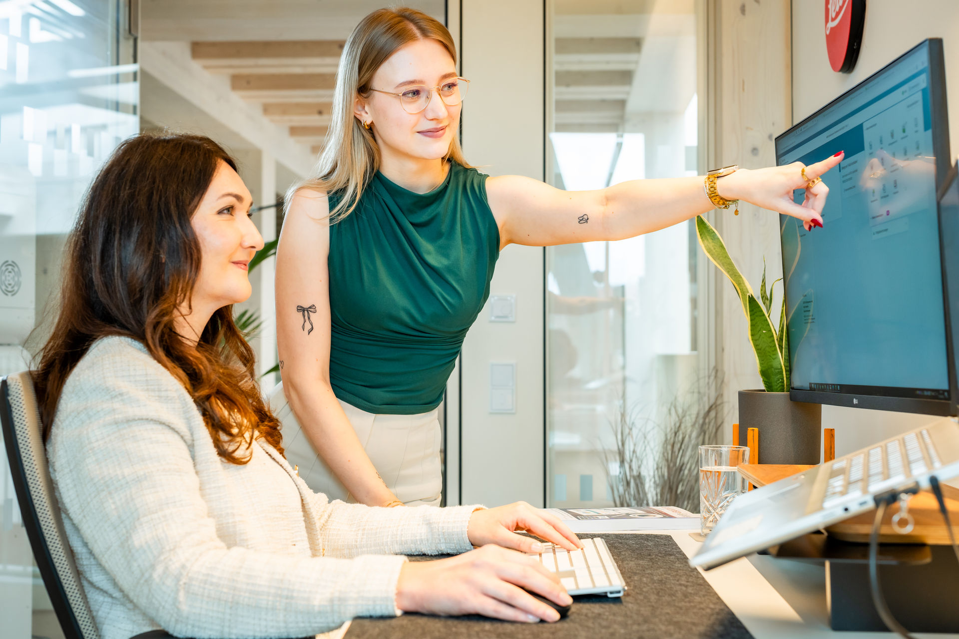 Zwei Frauen schauen gemeinsam auf den Laptop-Bildschirm beim Controlling und Coaching.