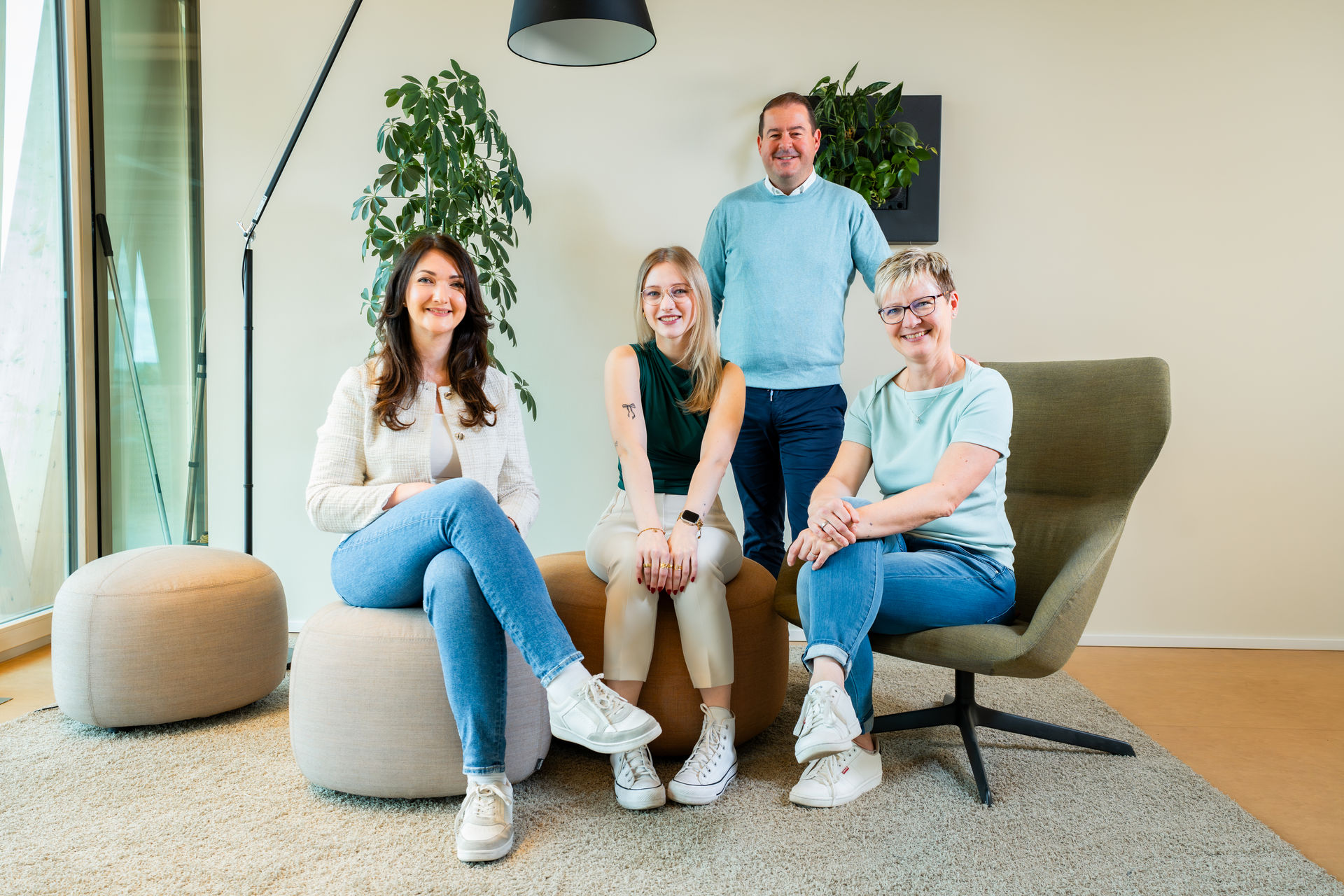 Team der b+ GmbH mit Geschäftsführer und drei Mitarbeiterinnen im modernen Büro.