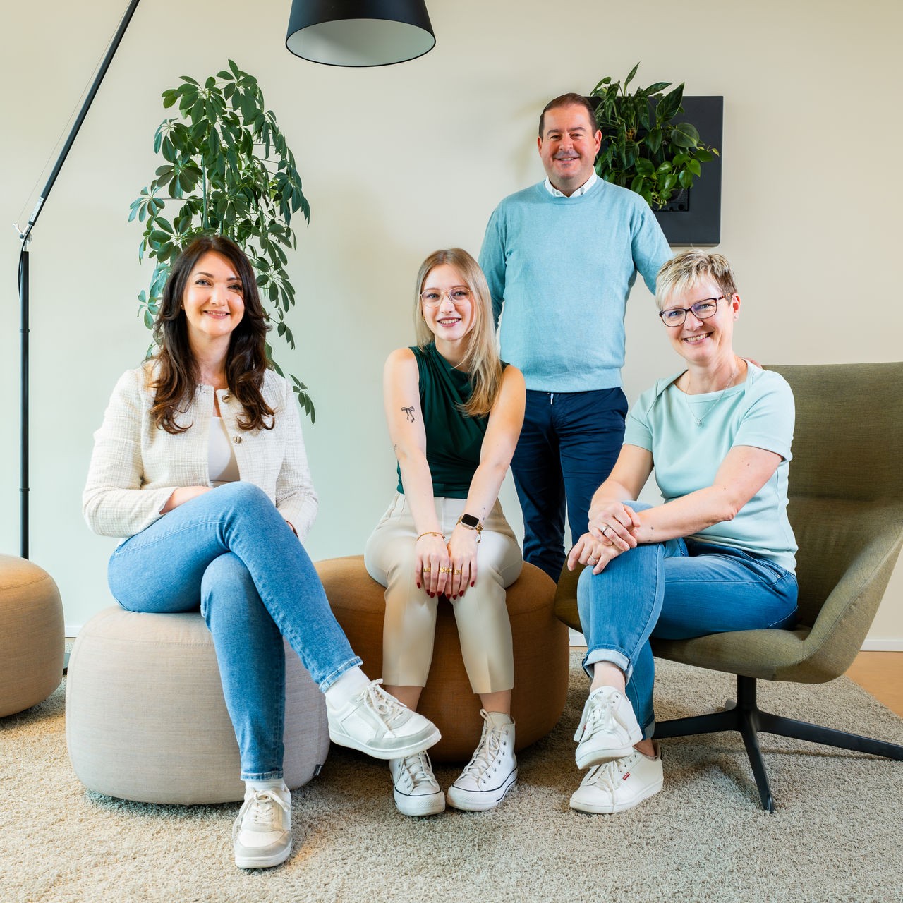 Team der b+ GmbH sitzt zusammen in der Büro-Lounge.