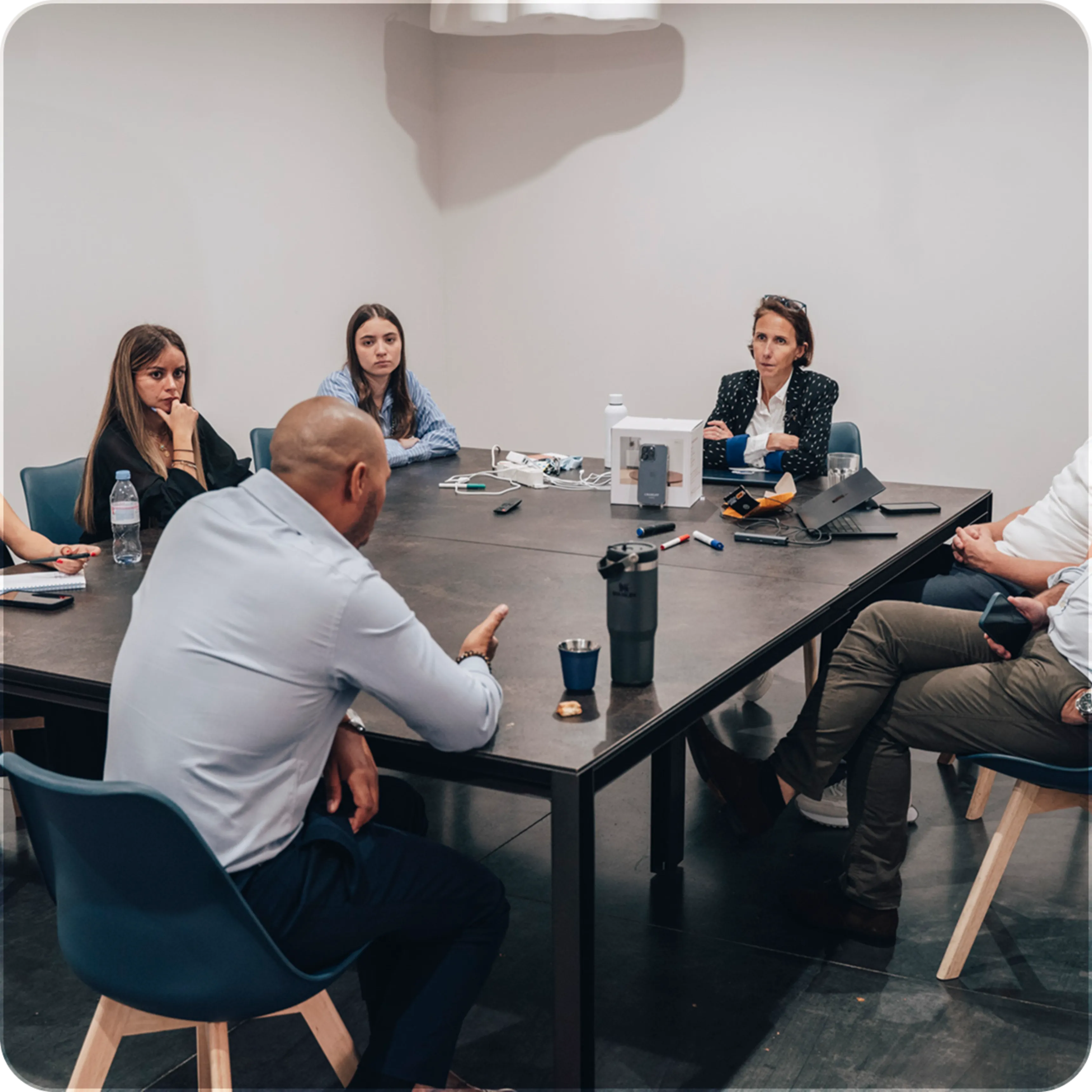 Group of professionals seated around a conference table in a business meeting.