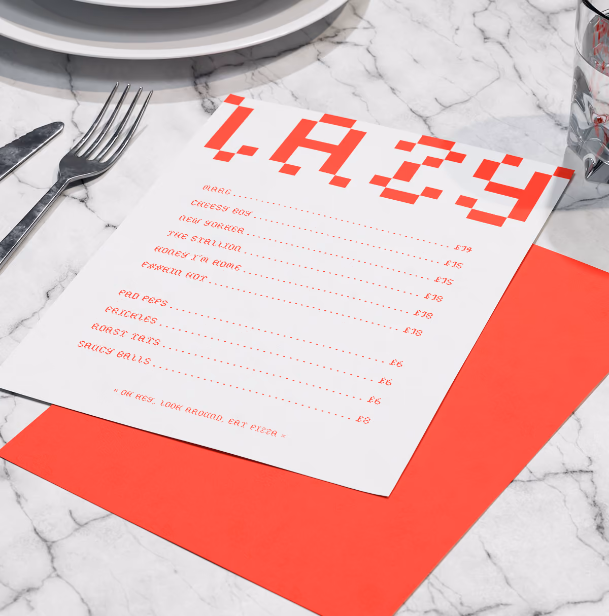 A LazyType Mockup showing a red and white pizza menu titled LAZY with items and prices on marble table with fork, knife, plates, and glass.