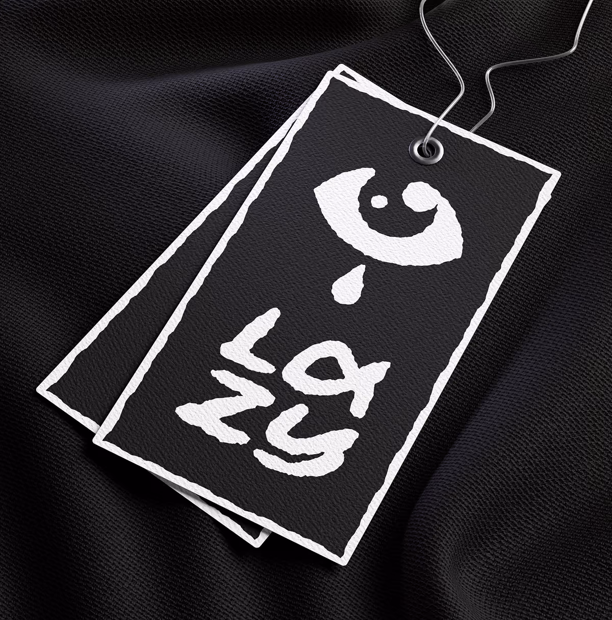 A LazyType Mockup with black fabric with black tags roughly outlined in white, featuring a stylised eye and text 'Lazy'.