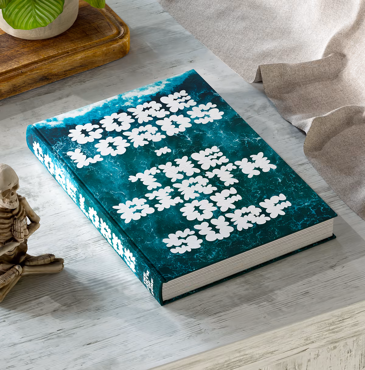 A LazyType Mockup with a closed book with teal ocean wave cover and white lumpy text 'Core Lords - The Birth of Surf' on a light wooden table.