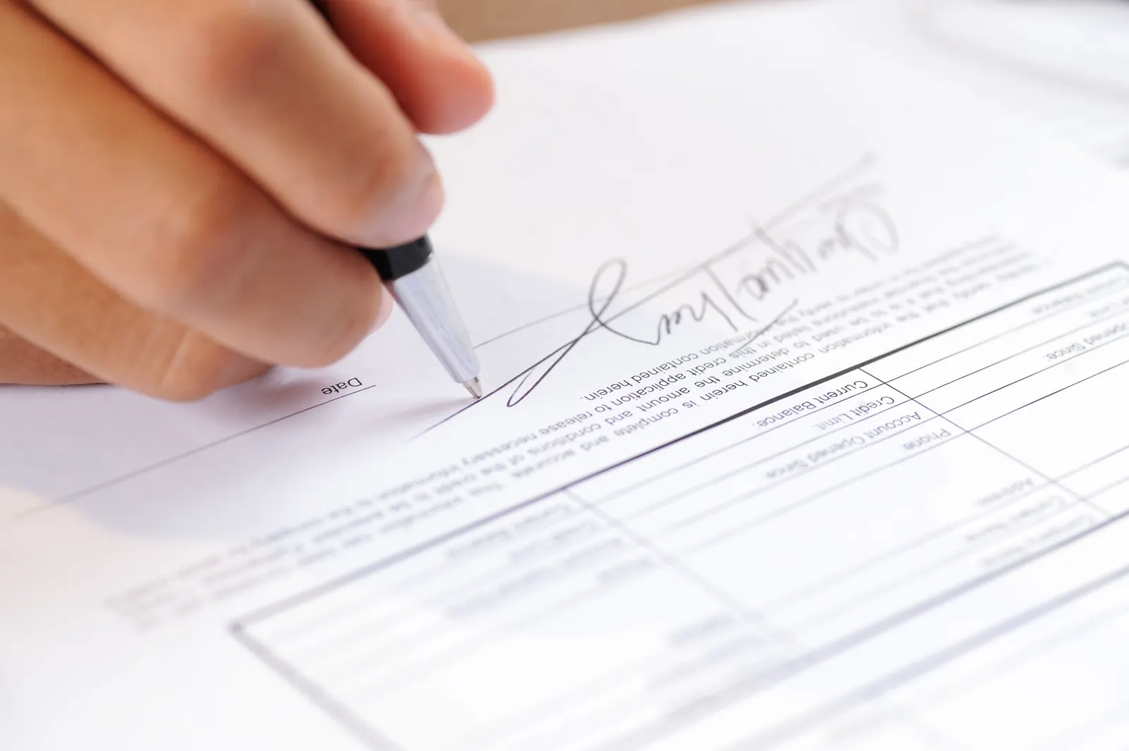 Close-up of a person signing a legal document