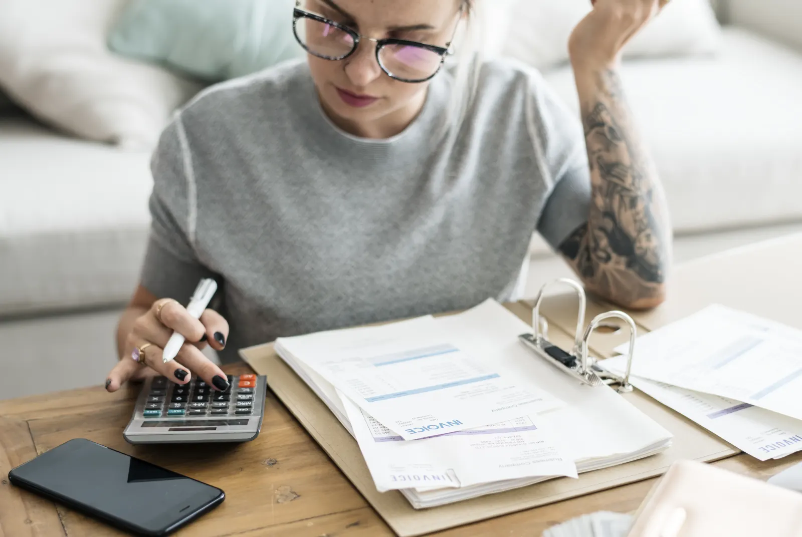 Person reviewing a stack of bills and invoices