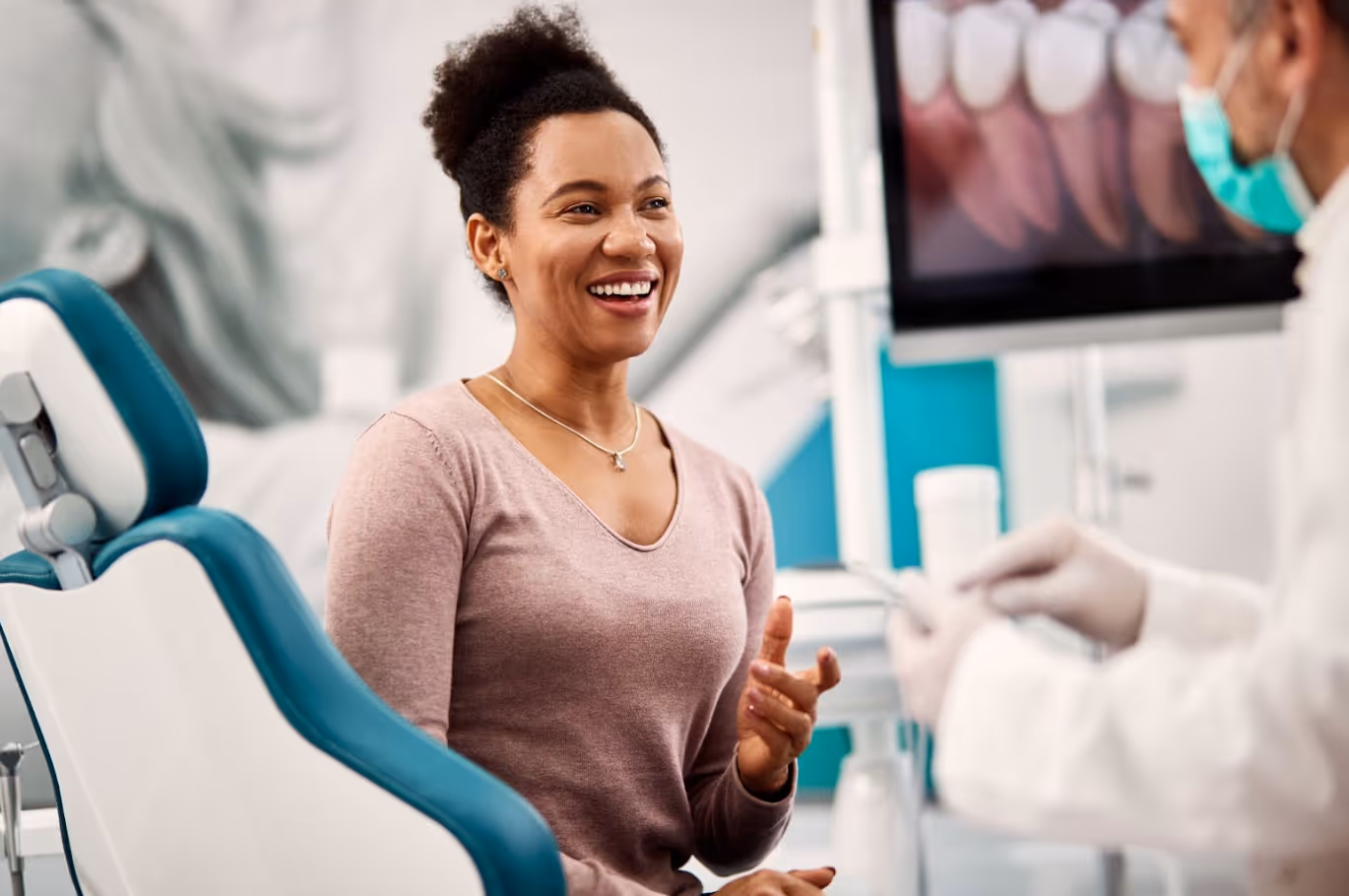 Patient smiling and talking with a dentist during a relaxed office visit