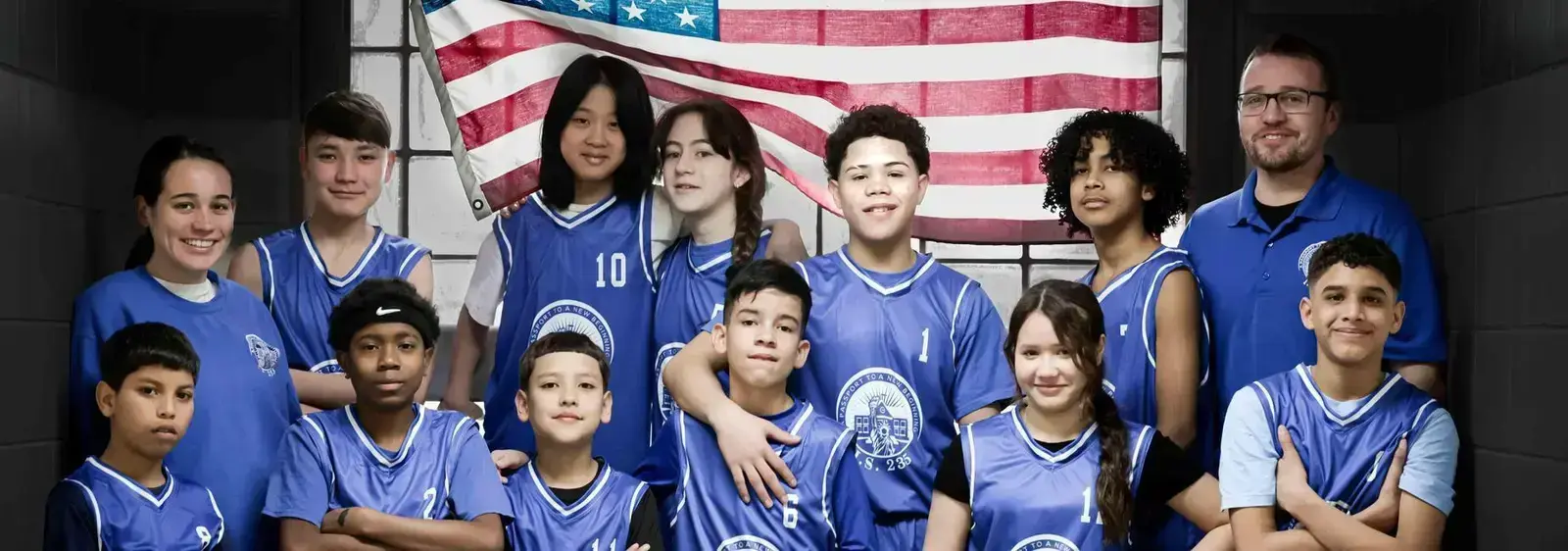 Middle school basketball team posing with coach and American flag