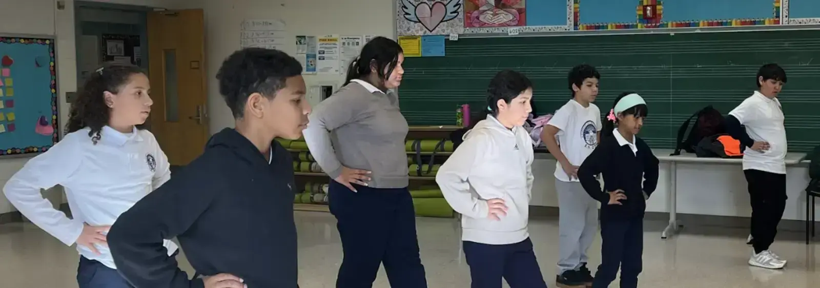 Students practicing dance or movement exercise in a classroom