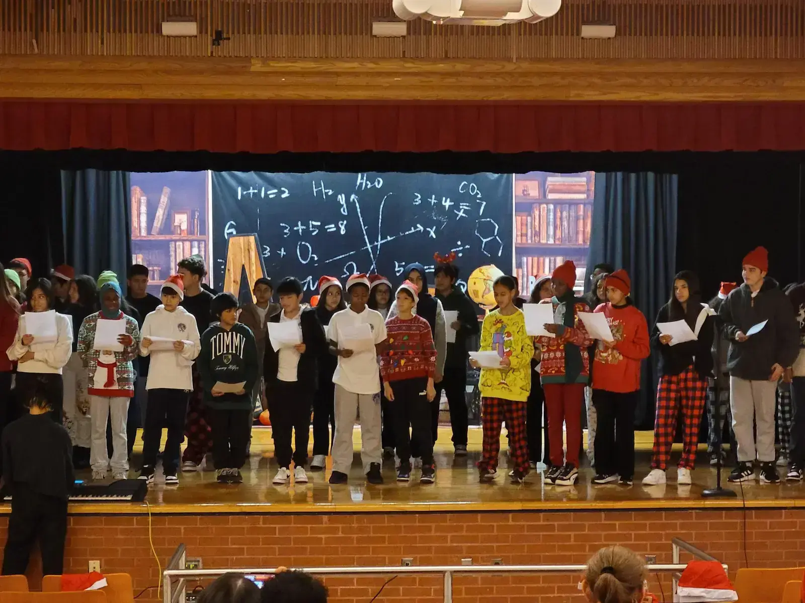 Students in holiday attire performing on stage at school winter concert