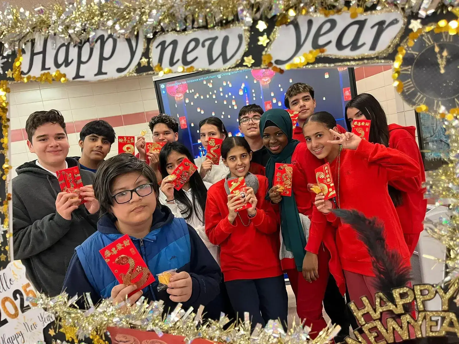Students holding red envelopes celebrating Lunar New Year 2025
