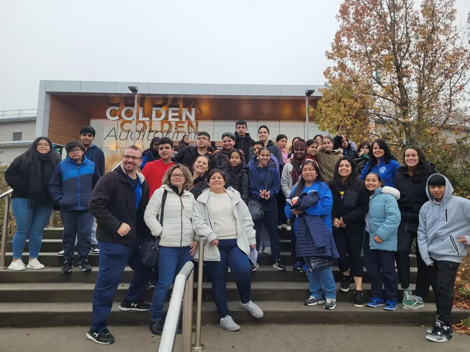 Students and staff pose on steps outside Colden Auditorium