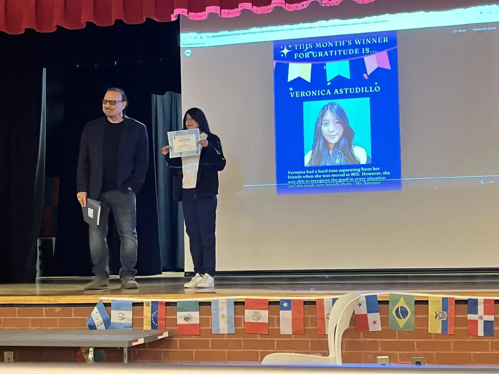 Student Veronica Astudillo receives gratitude award certificate on stage