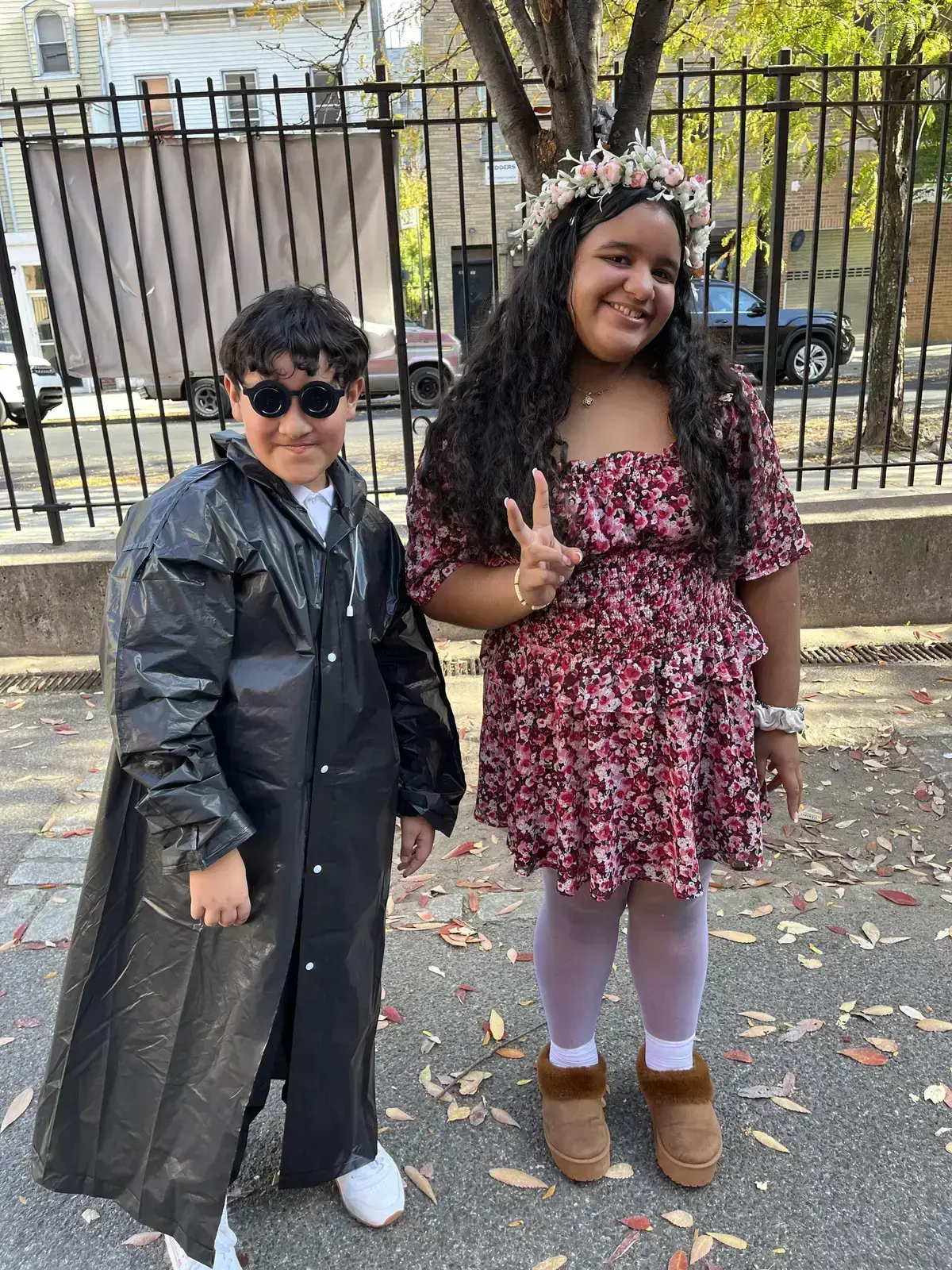 Two students in Halloween costumes posing outside school