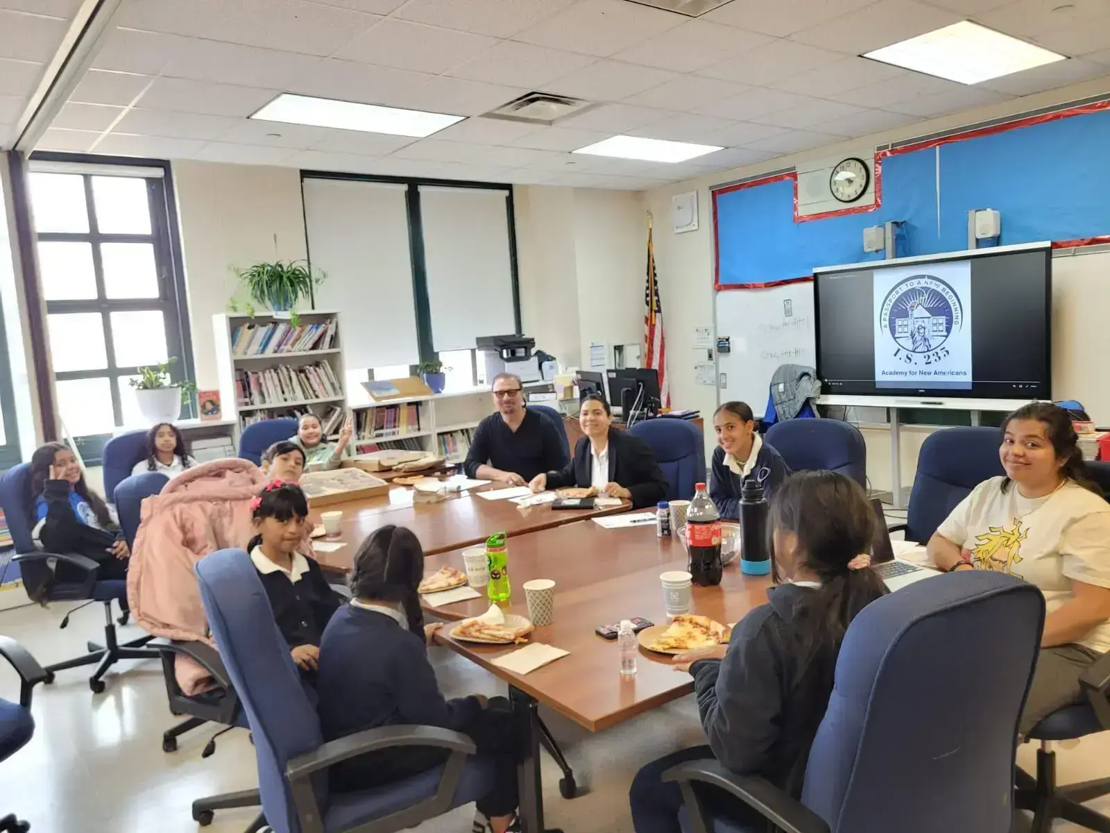 Students and teachers share pizza at an IS 235 classroom meeting