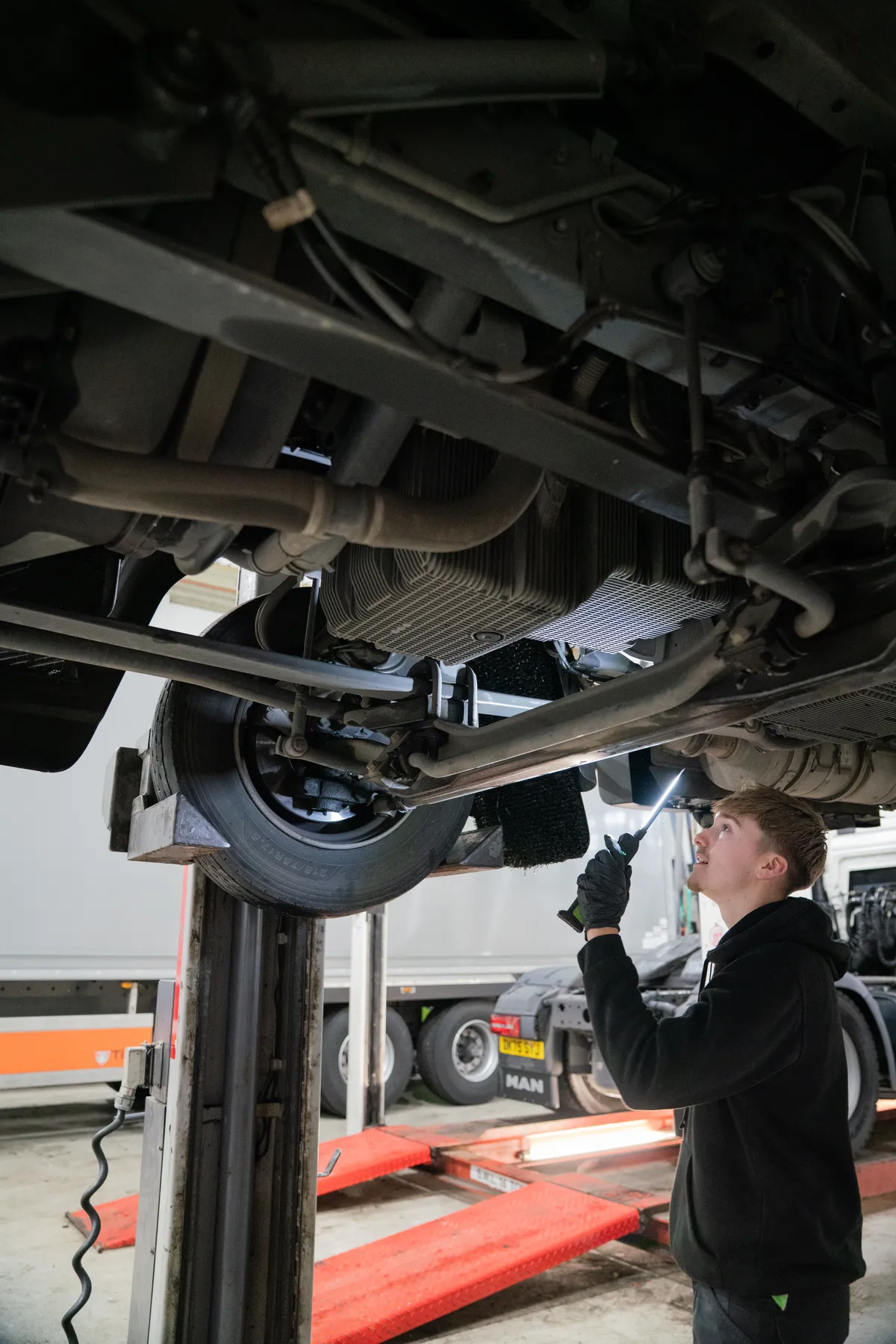Young technician working underneath vehicle