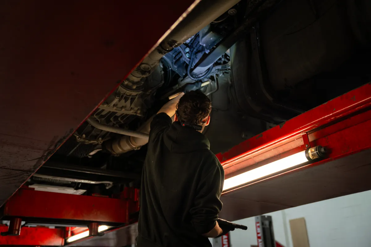 Technician working underneath vehicle