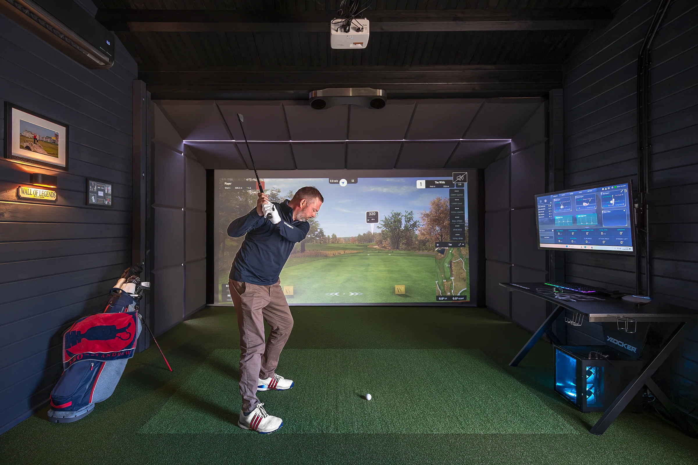 Guest taking a swing in the private golf simulator cabin