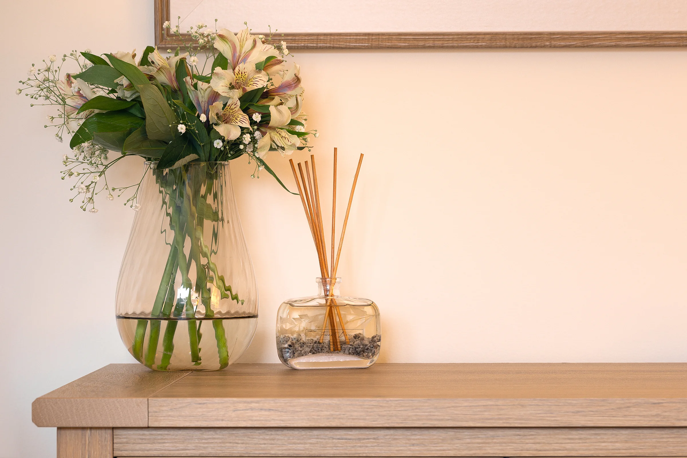 Fresh flowers and a diffuser on a console table