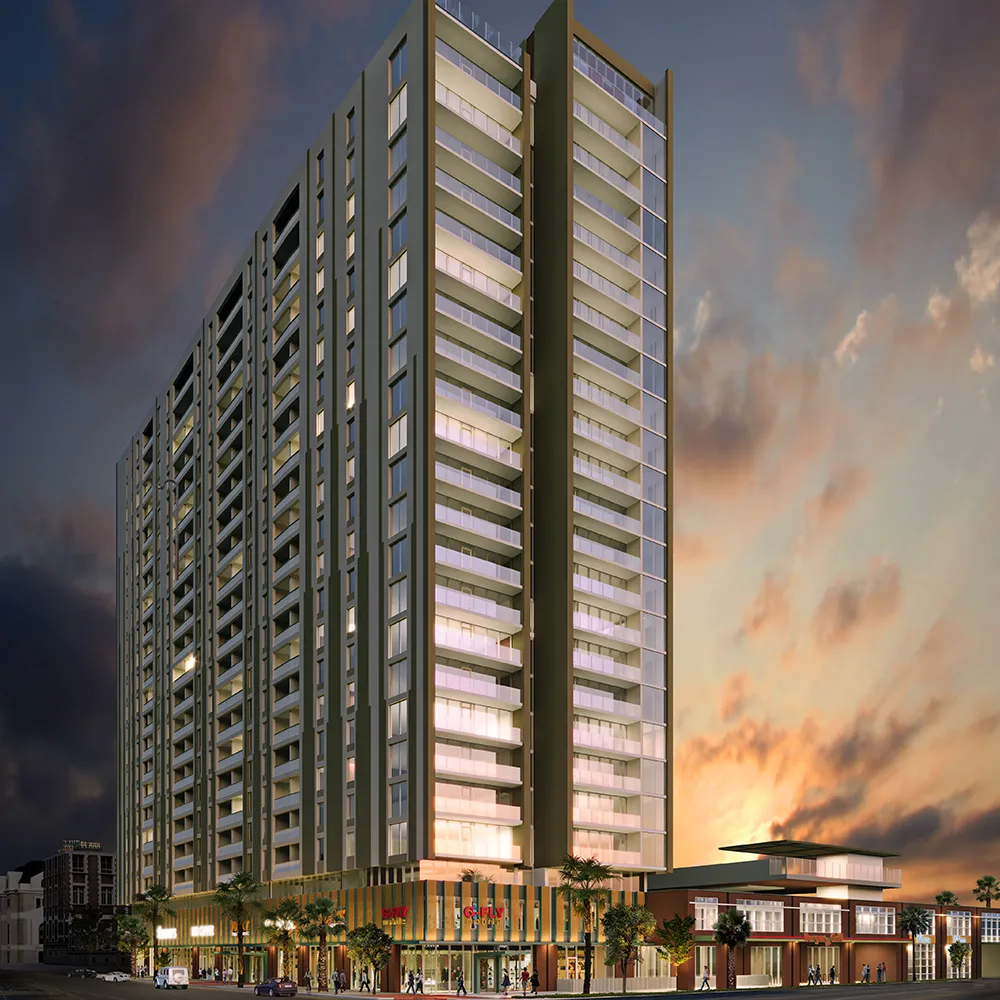 The Whitney, a tall modern apartment building with balconies at sunset and illuminated ground-floor retail shops.