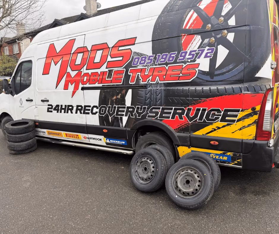 White van with Mods Mobile Tyres branding and four tires placed on the ground beside it.
