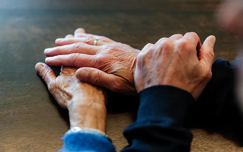 Ouder stel houdt elkaars hand vast als symbool voor de 8-weekse EFT-relatietraining van Voordeliefde