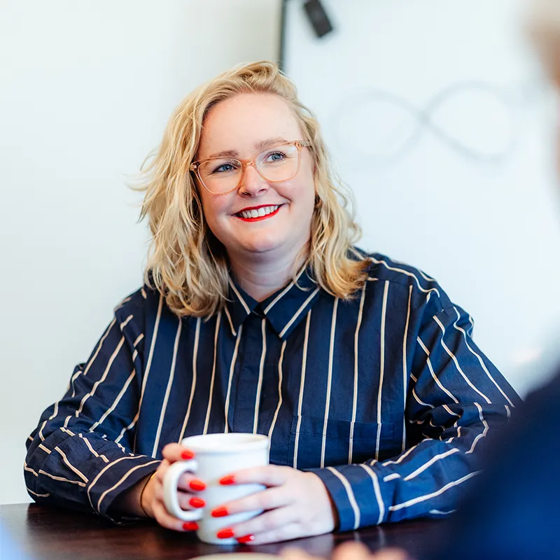 Relatiecounselor Jolien glimlachend aan tafel tijdens een EFT-traject voor stellen bij Voordeliefde