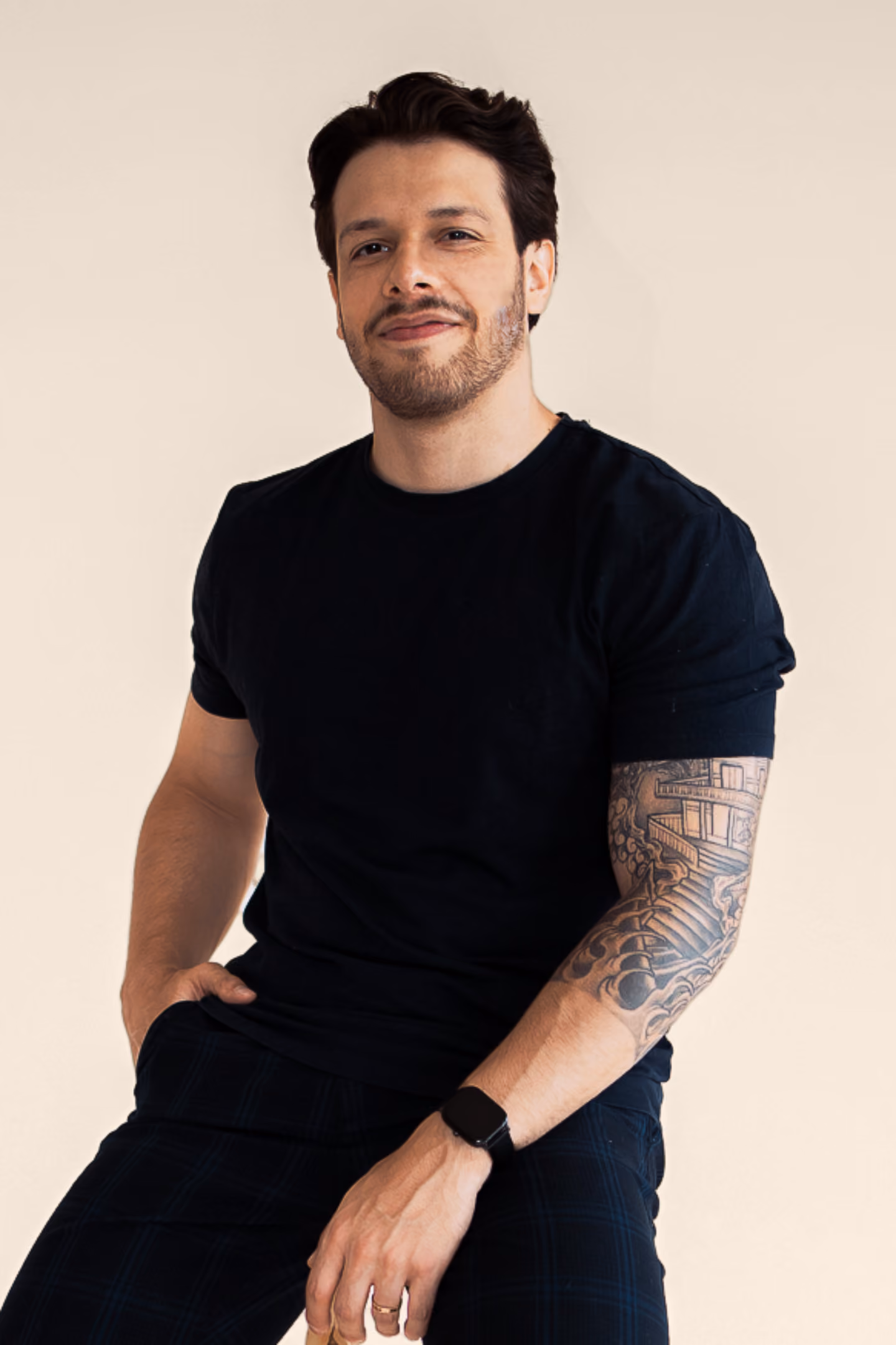 Vitor Orem wearing a black t-shirt, posing against a plain light beige background.