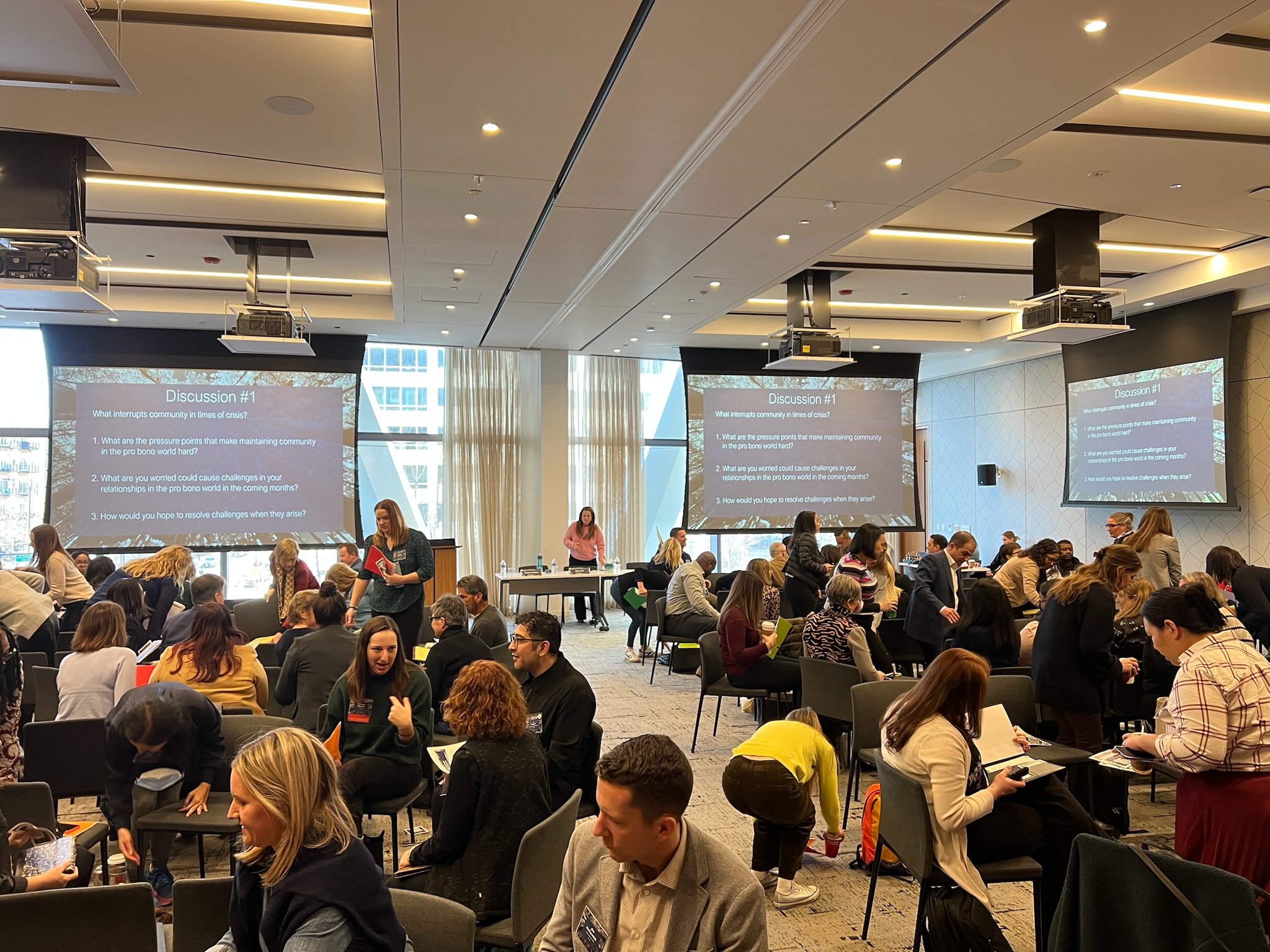 Group of people in small discussion groups during a workshop in a conference room.