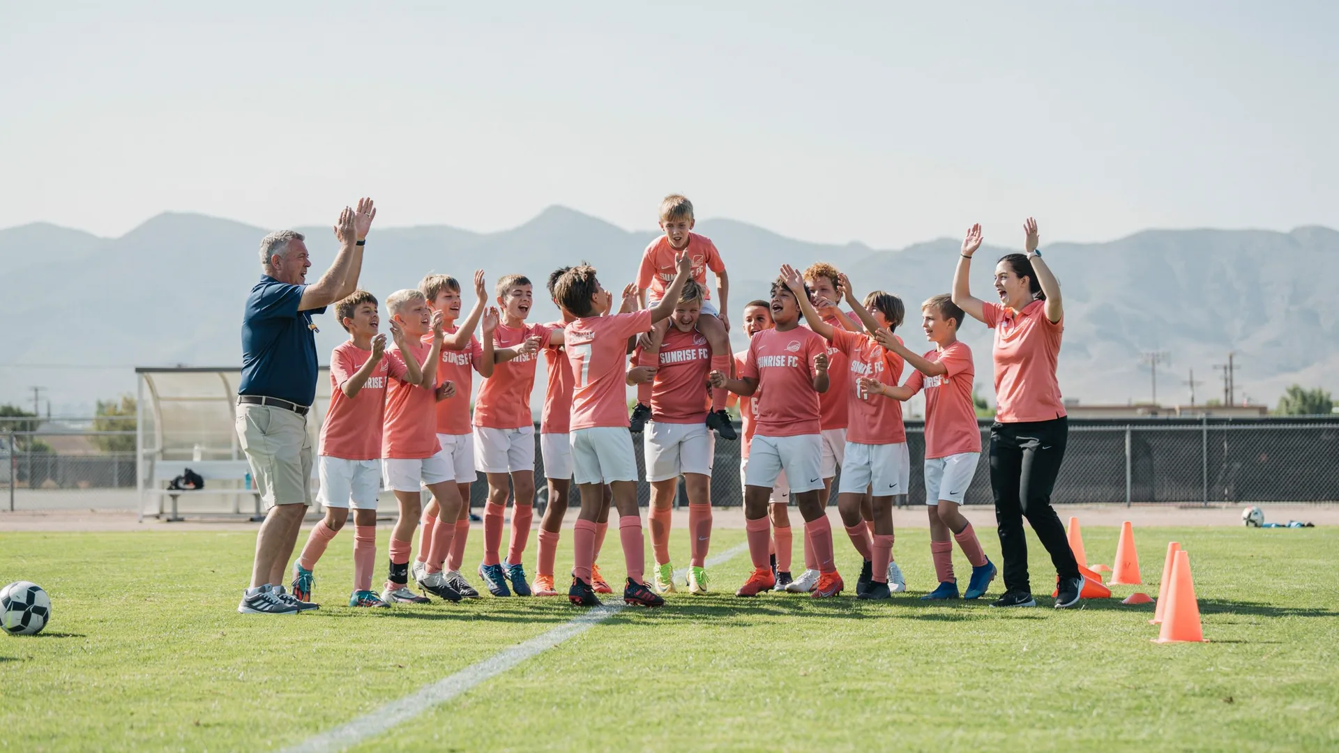 Youth soccer team in matching jerseys huddled in a group cheer