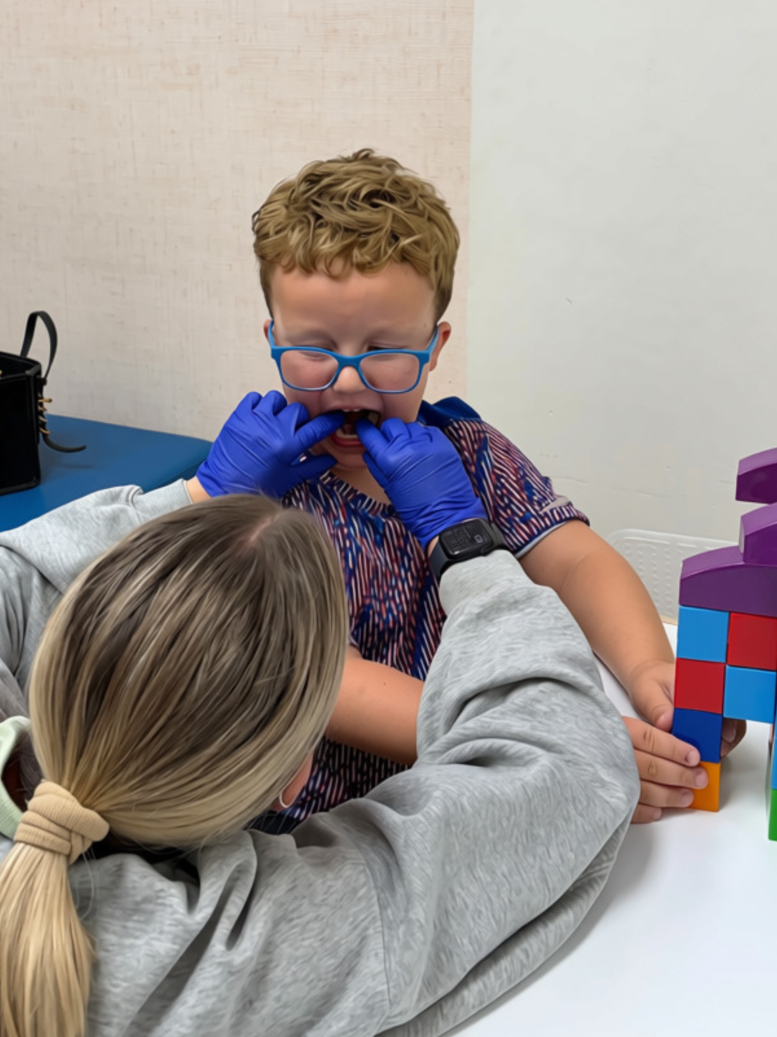 Child participating in an oral-function exercise during therapy.