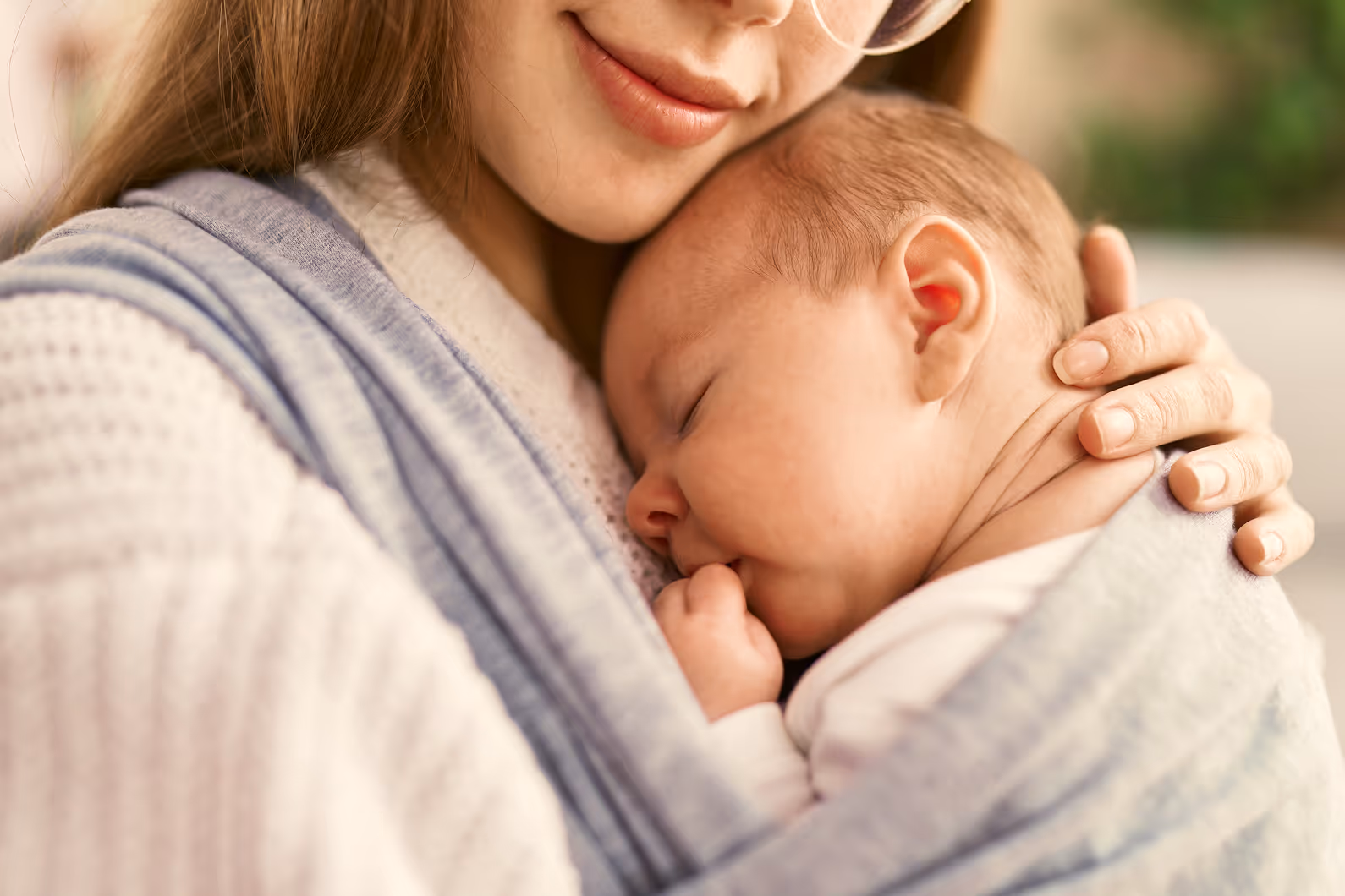 A parent holding their baby calmly and close.