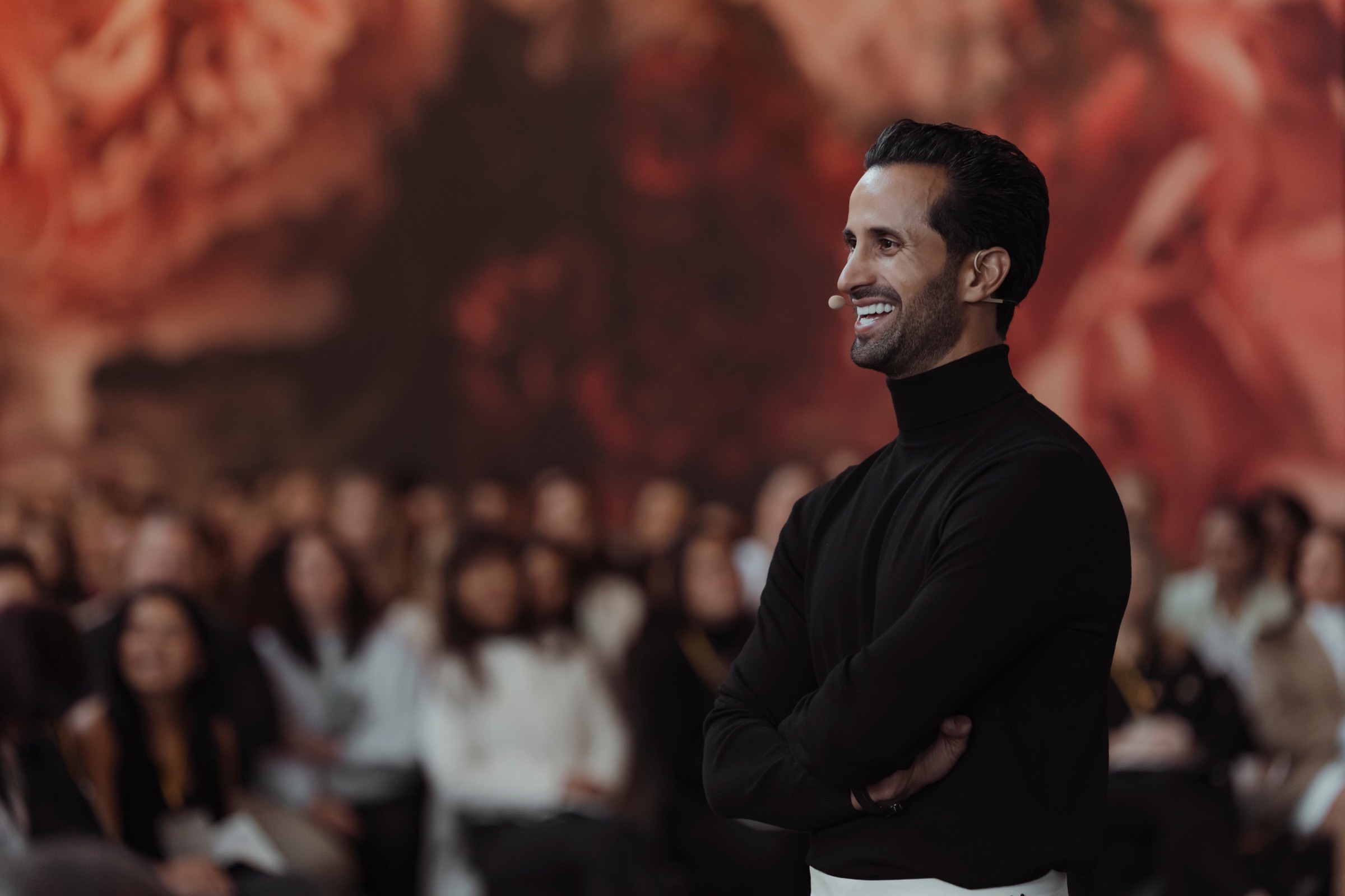 David Ghiyam smiling on stage in front of a live audience
