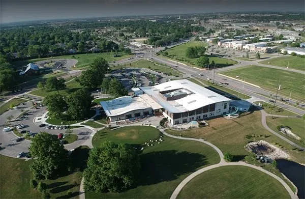 Aerial view of a modern civic building in Olathe, Kansas with landscaped grounds and walking paths