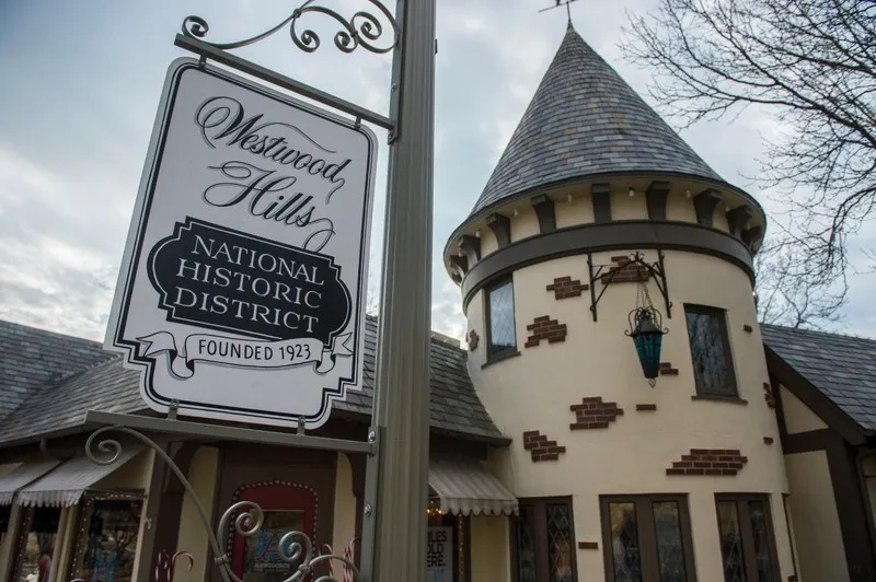 "Westwood Hills National Historic District, Founded 1923" sign beside a turreted Tudor building