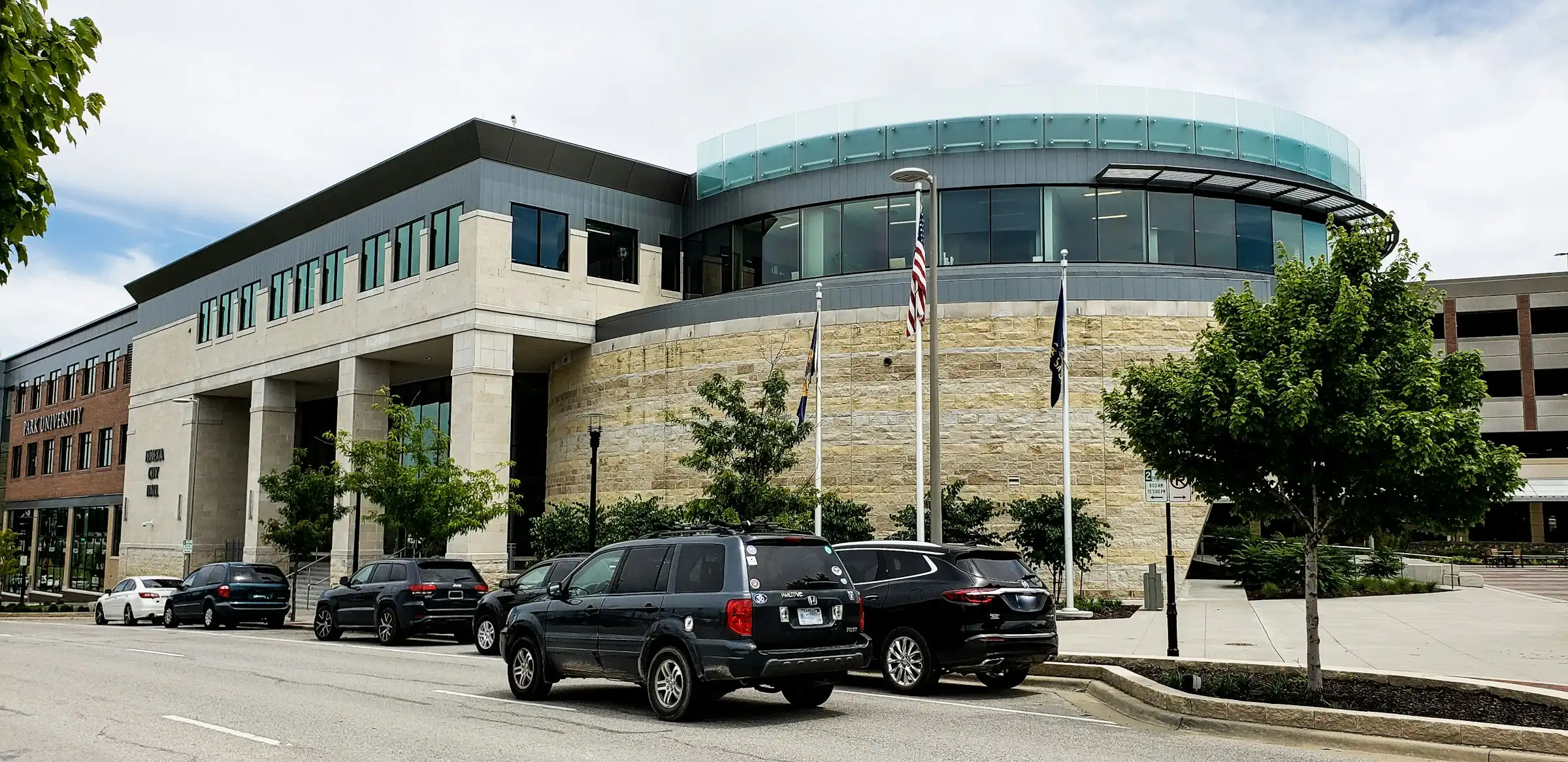 Lenexa City Hall in Lenexa City Center, with flags out front and cars parked along the street