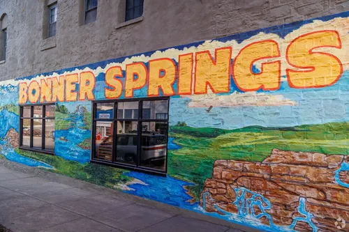Colorful Bonner Springs mural painted along a downtown brick building beside a storefront window